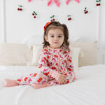 Baby romper in pink checker bamboo fabric with cherries and bows, featuring a two-way zipper and fold-over feet.