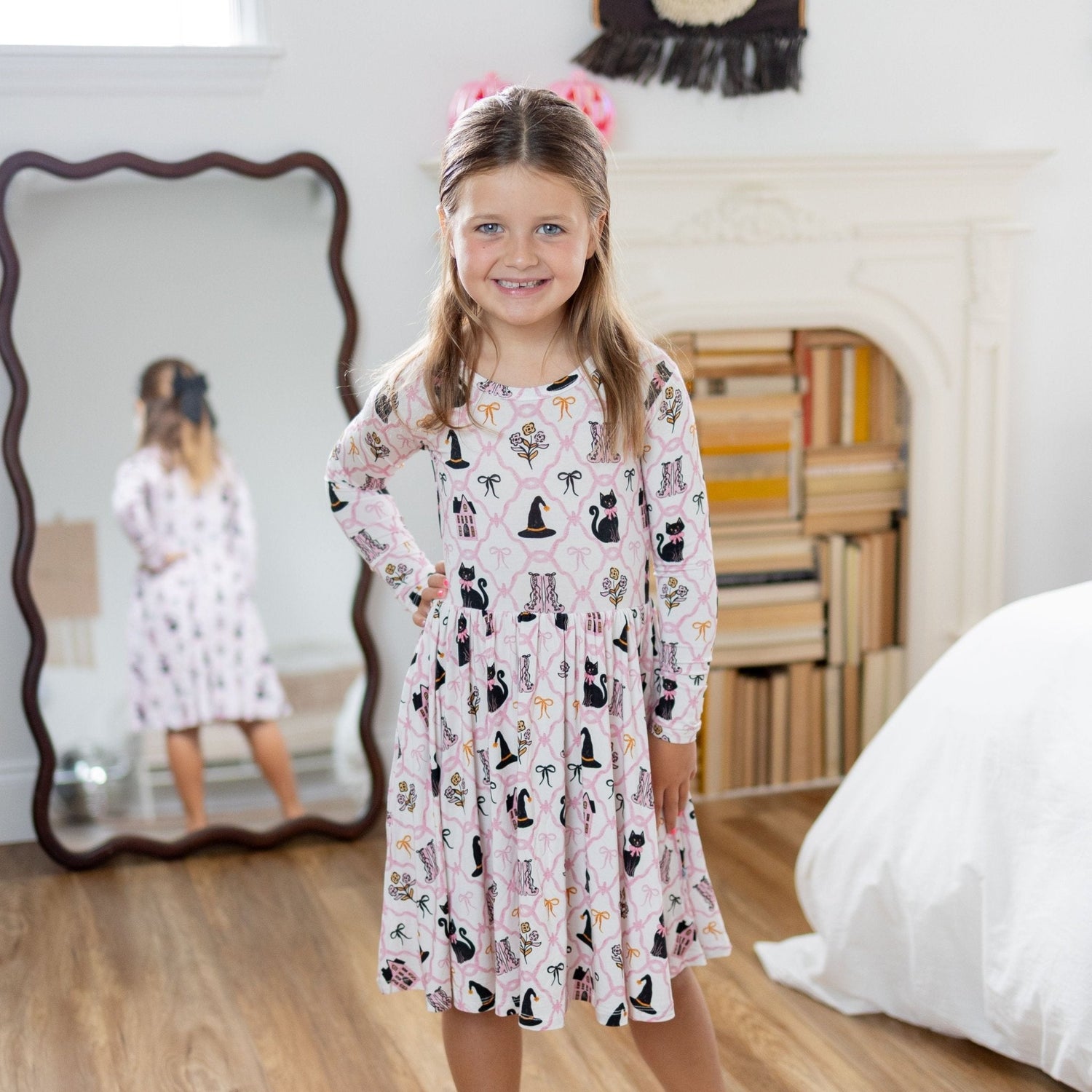 Long sleeve blush twirl dress with black cats, witch hats, and bows in a Halloween print