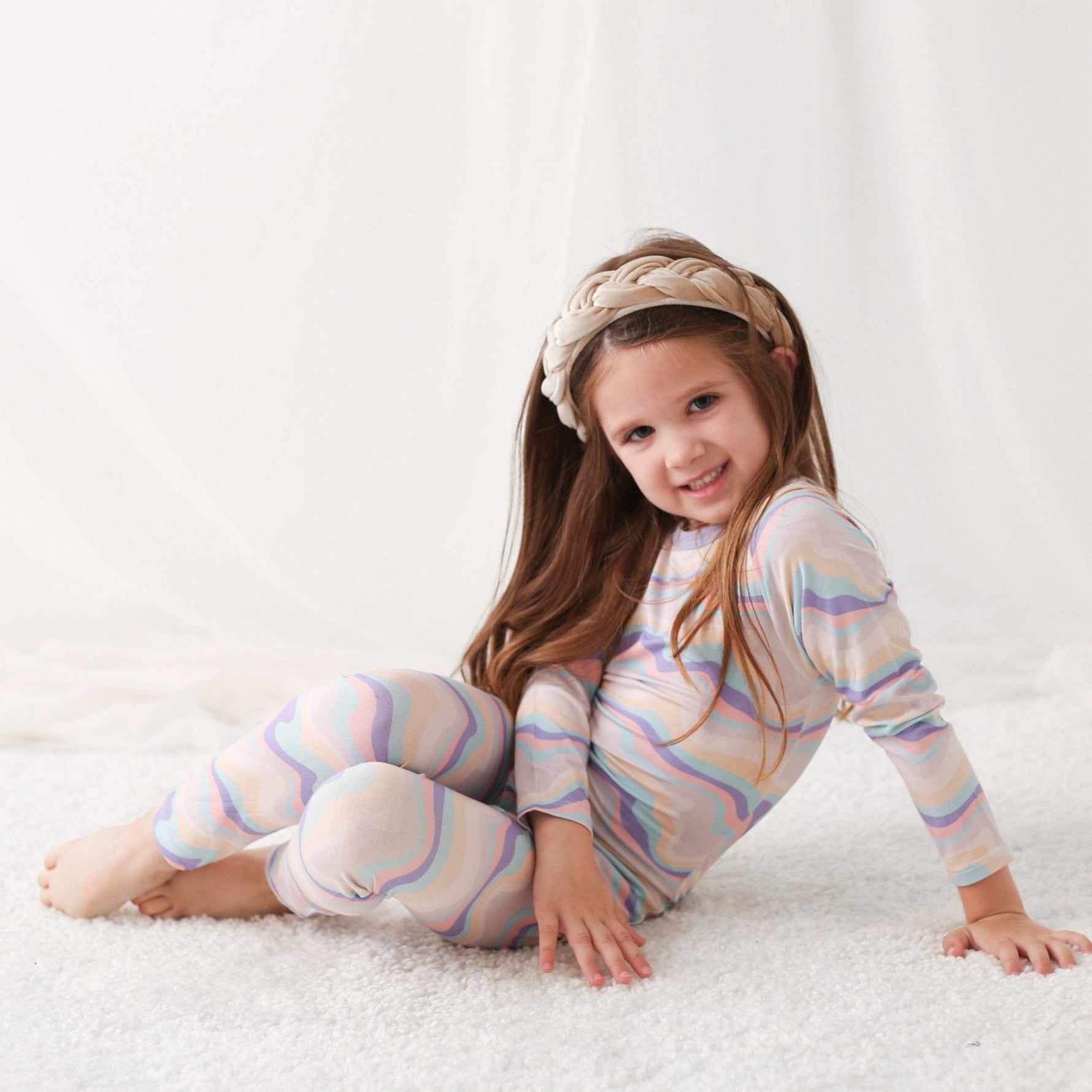 Two-piece baby pajama set with swirl pattern, long-sleeve top and matching pants.