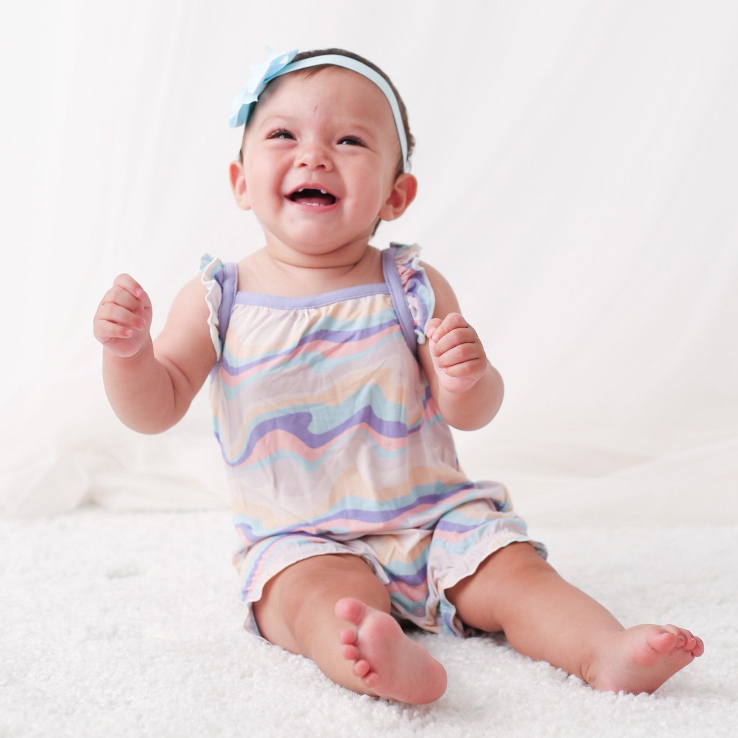 Bubble romper with flutter sleeves in an all-over swirl print, with snaps along the legs