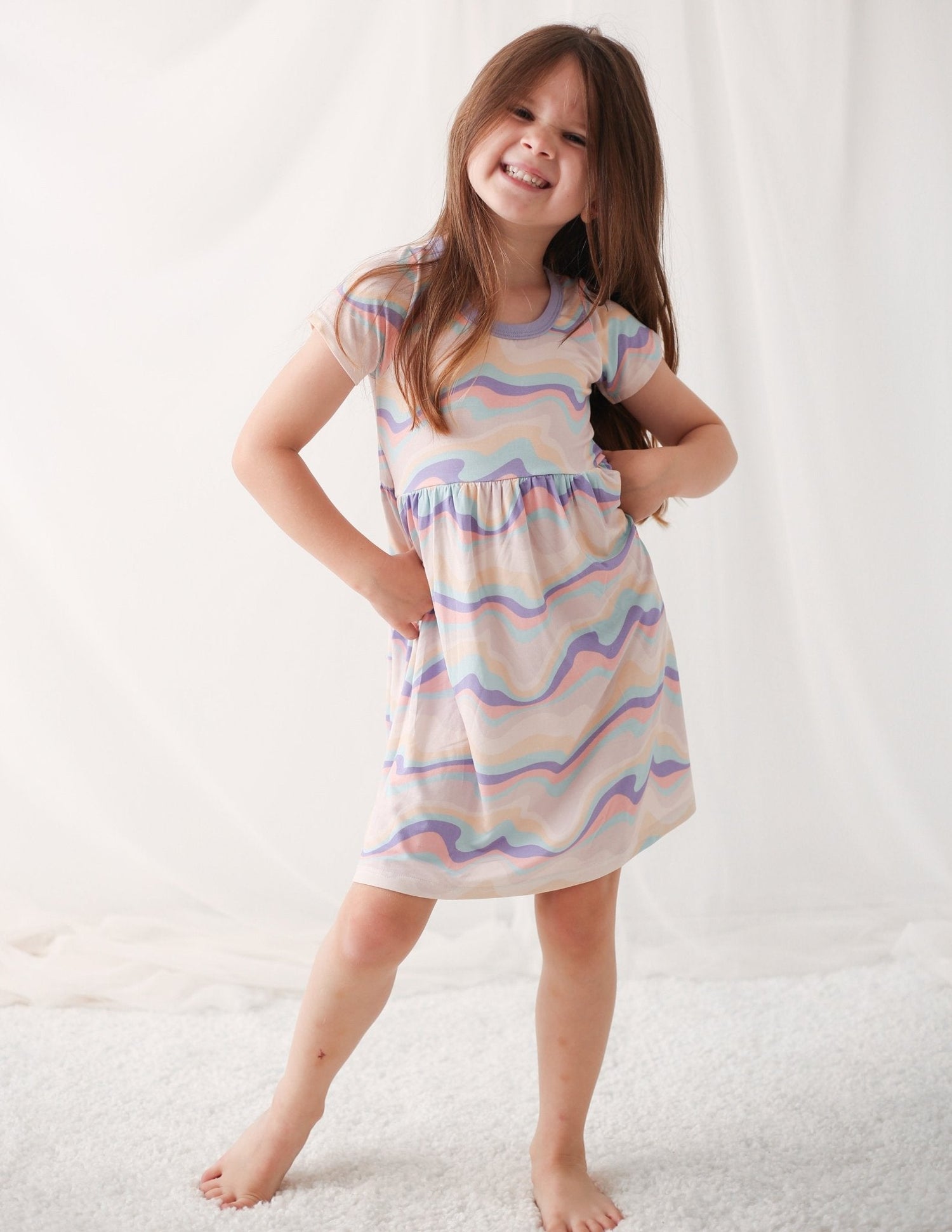 Baby dress with a swirls pattern in pink, short sleeves, and a flared skirt