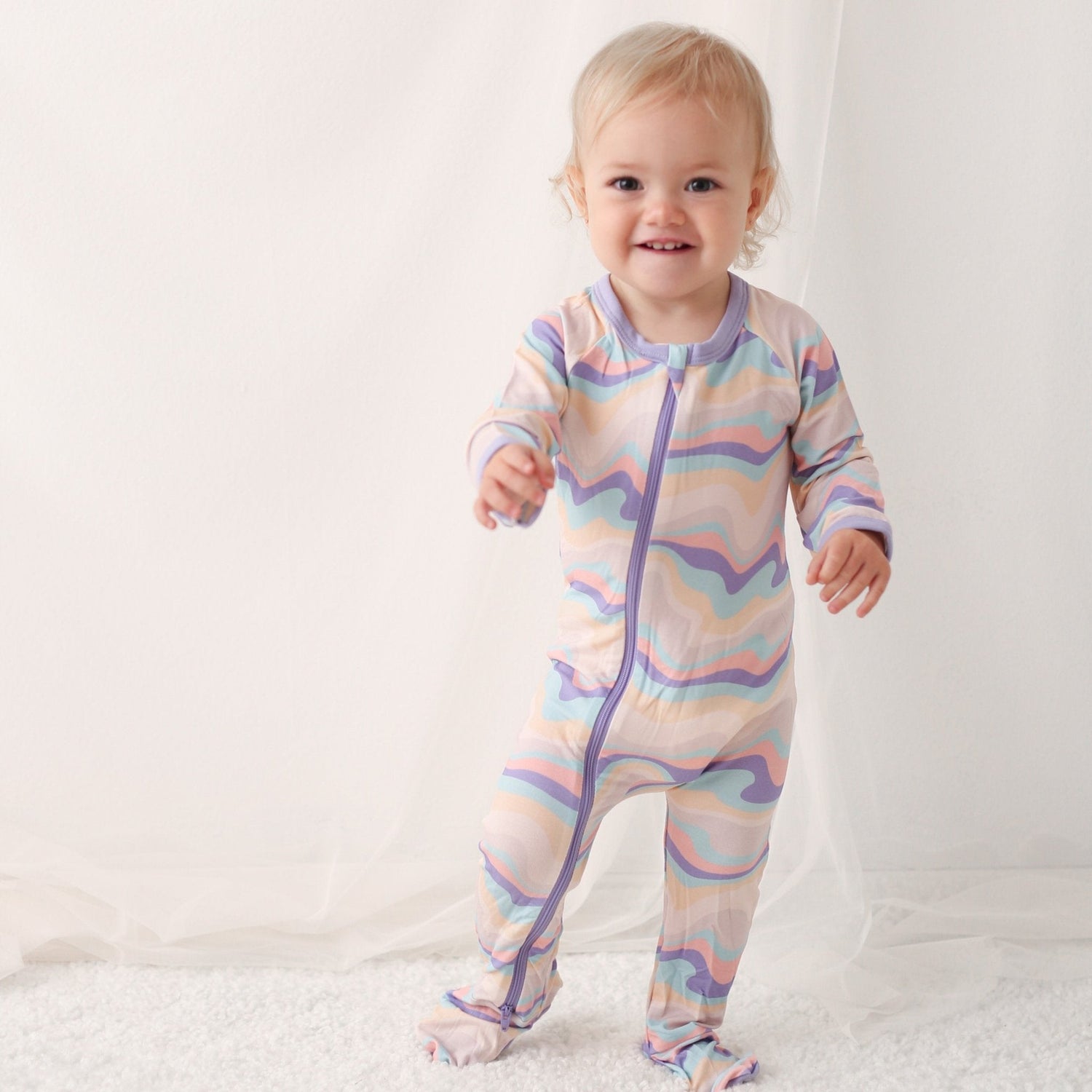 Baby footie pajamas with an allover swirl print, full-length zipper, and covered feet.