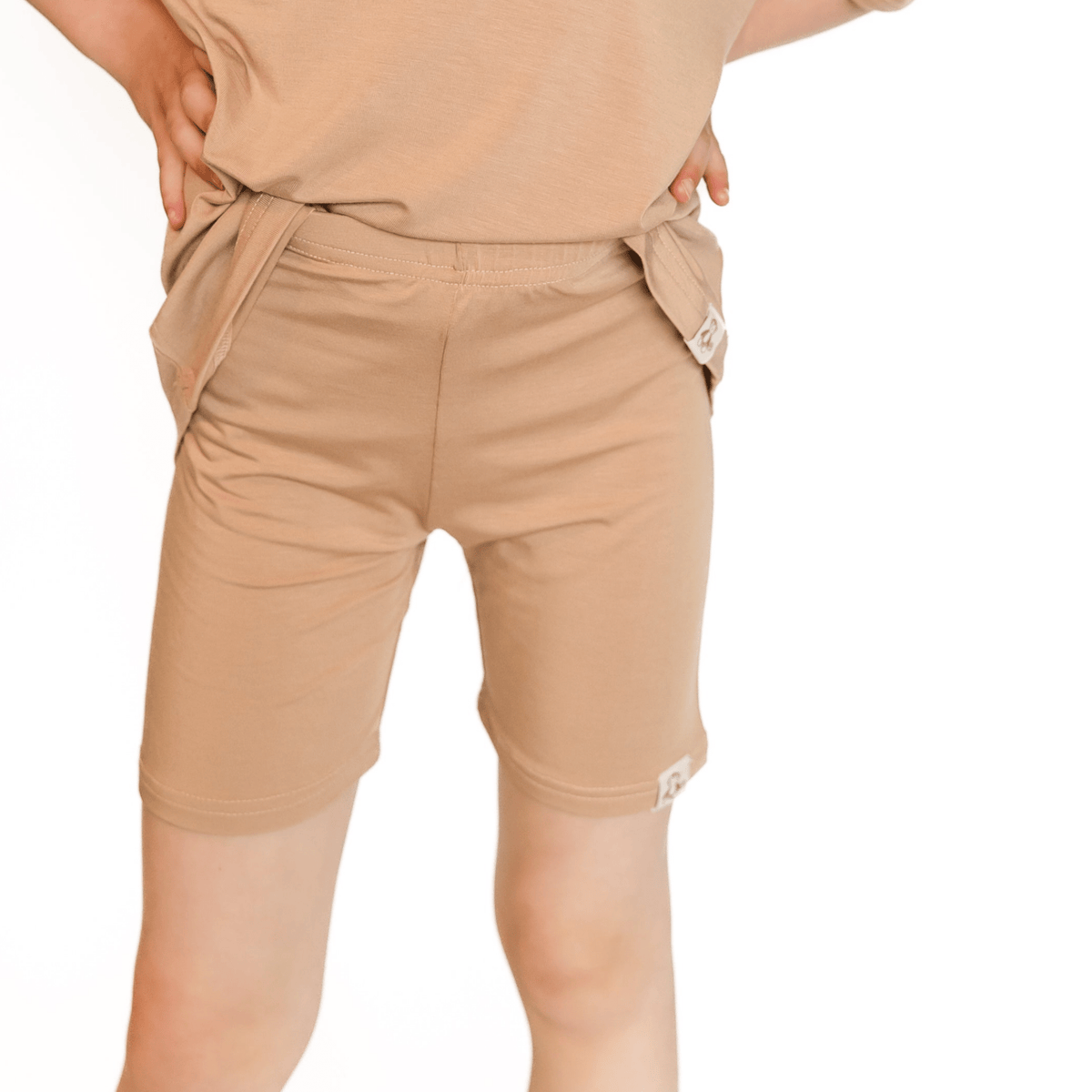 Tan toddler biker shorts laid flat, a fitted classic style in a solid neutral shade.