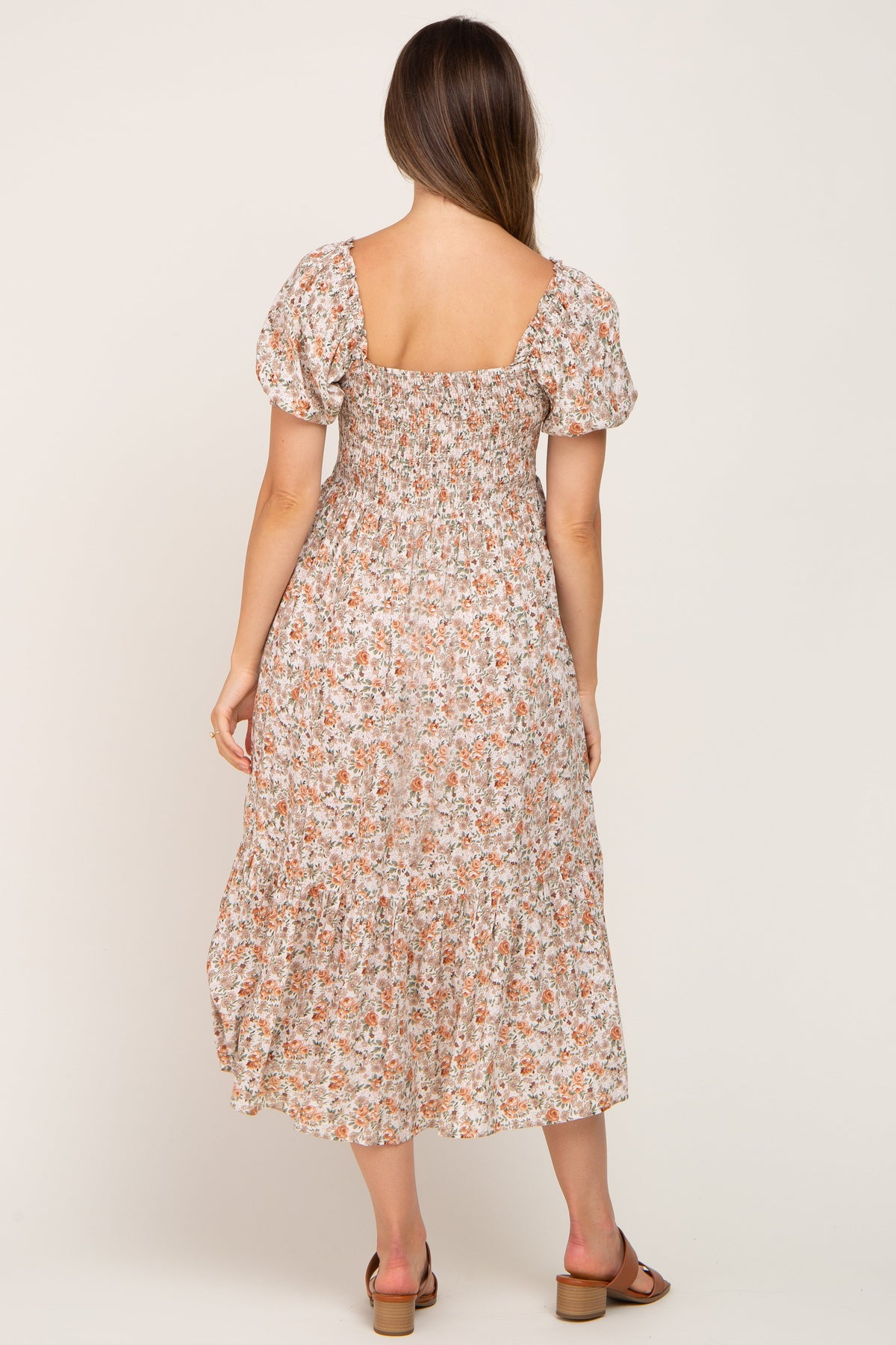 Woman wearing a Taupe Floral Smocked Puff Sleeve Maternity Midi Dress with floral print