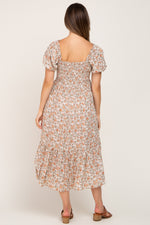 Woman wearing a Taupe Floral Smocked Puff Sleeve Maternity Midi Dress with floral print