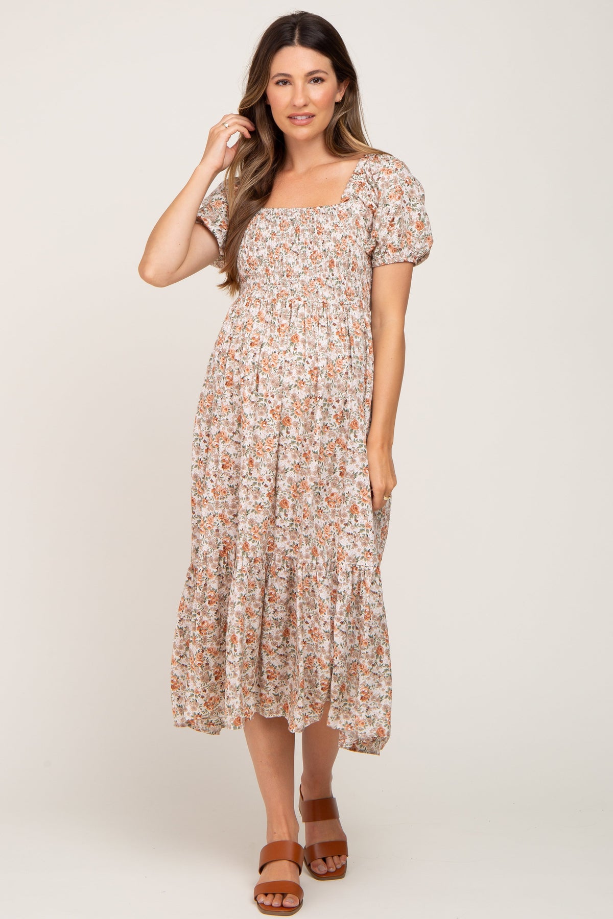 Woman wearing a Taupe Floral Smocked Puff Sleeve Maternity Midi Dress with floral print
