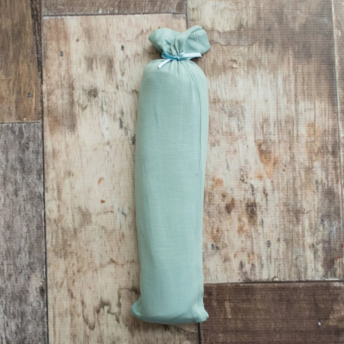 Teal swaddle blanket with a rope pattern, spread flat to show the square shape