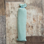 Teal swaddle blanket with a rope pattern, spread flat to show the square shape