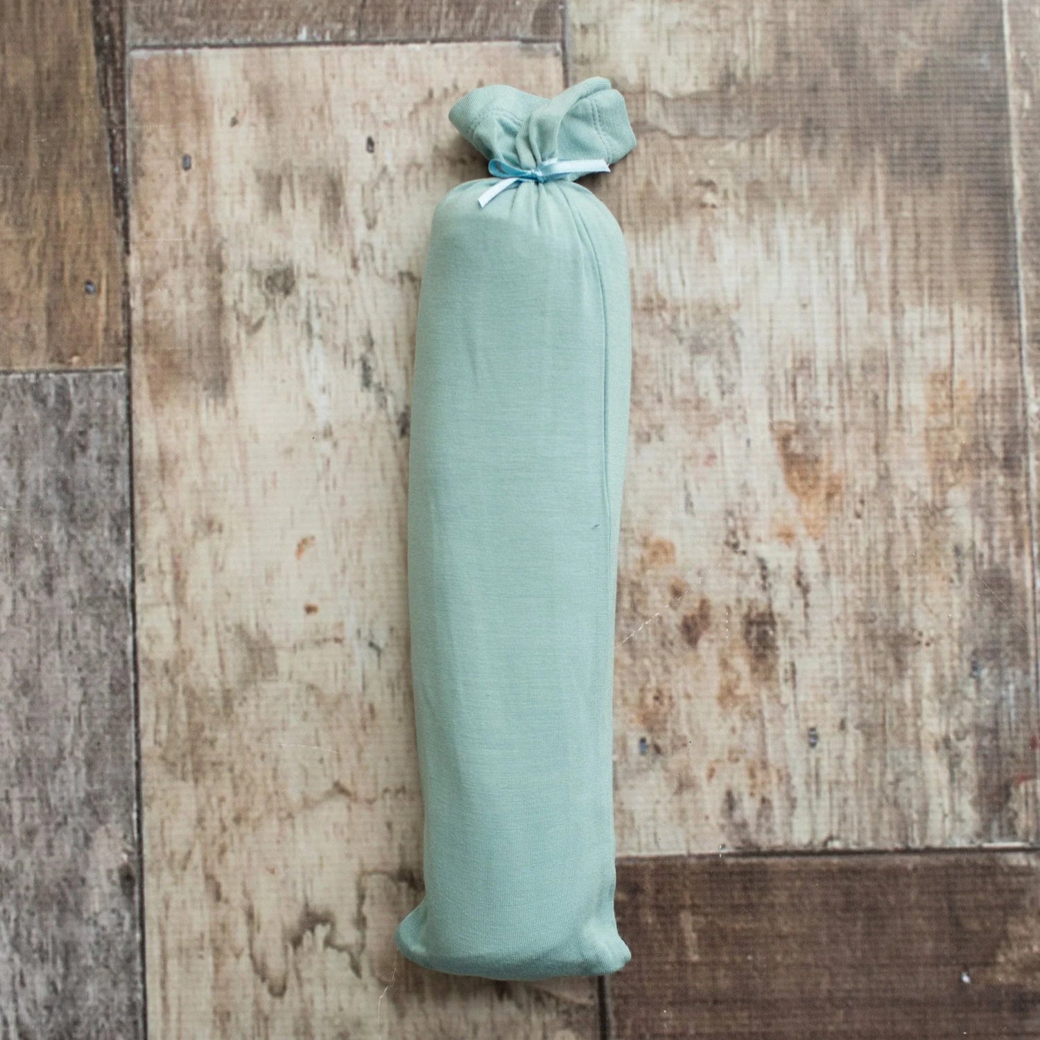 Teal swaddle blanket with a rope pattern, spread flat to show the square shape