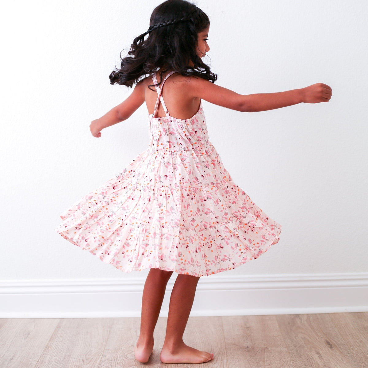 Pink floral dress with sparkly flowers, a flowy skirt, and a racer back, worn by a child.