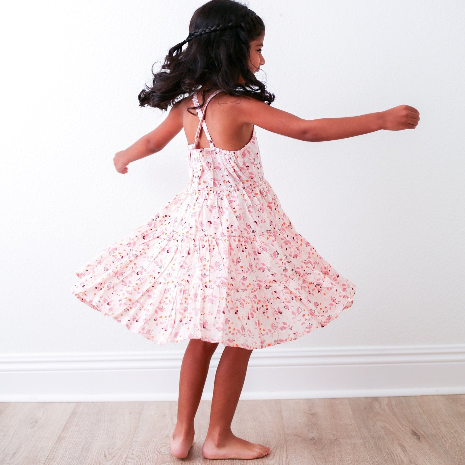 Pink floral dress with sparkly flowers, a flowy skirt, and a racer back, worn by a child.