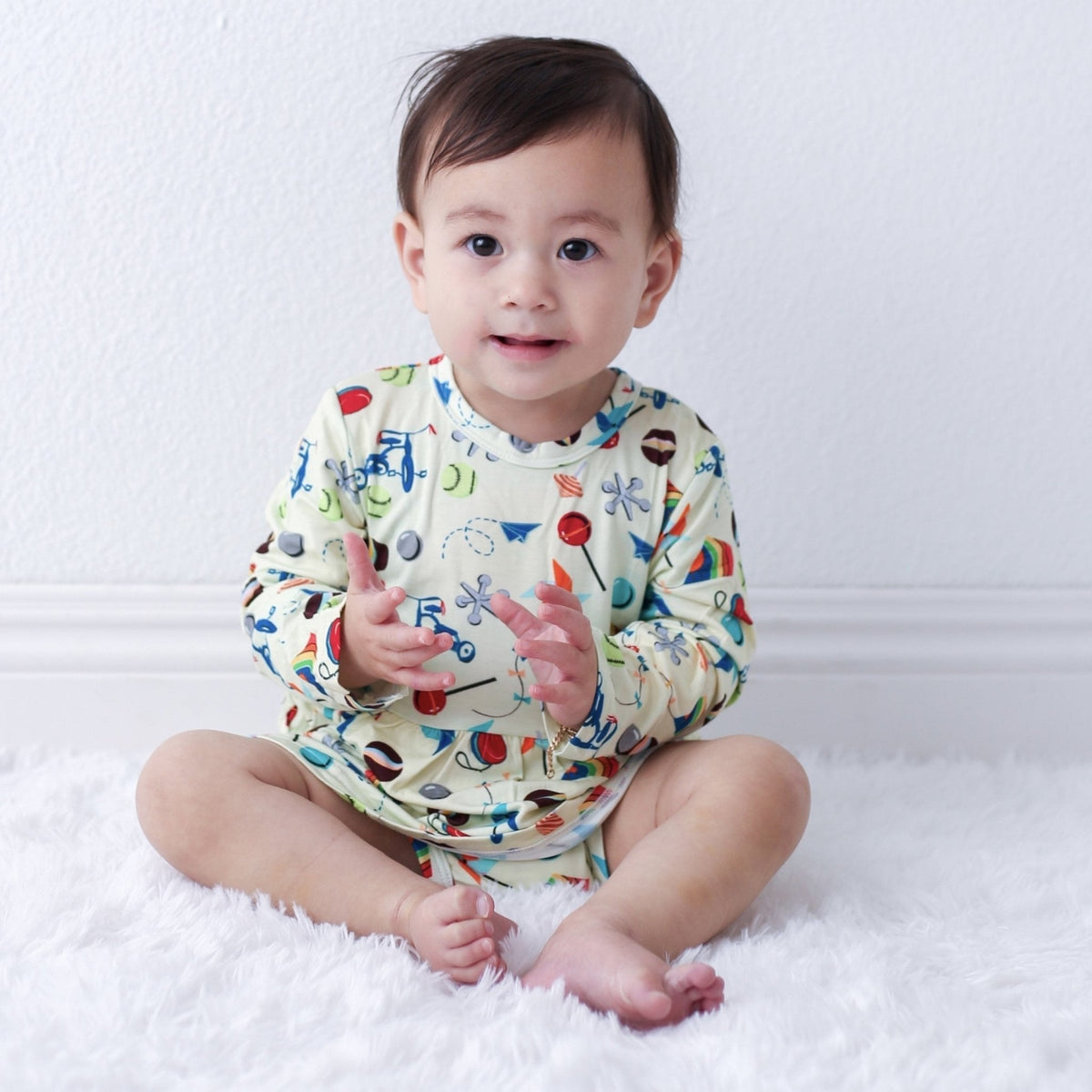 Long-sleeve bodysuit dress with a playful toys print and snap closure at the inseam