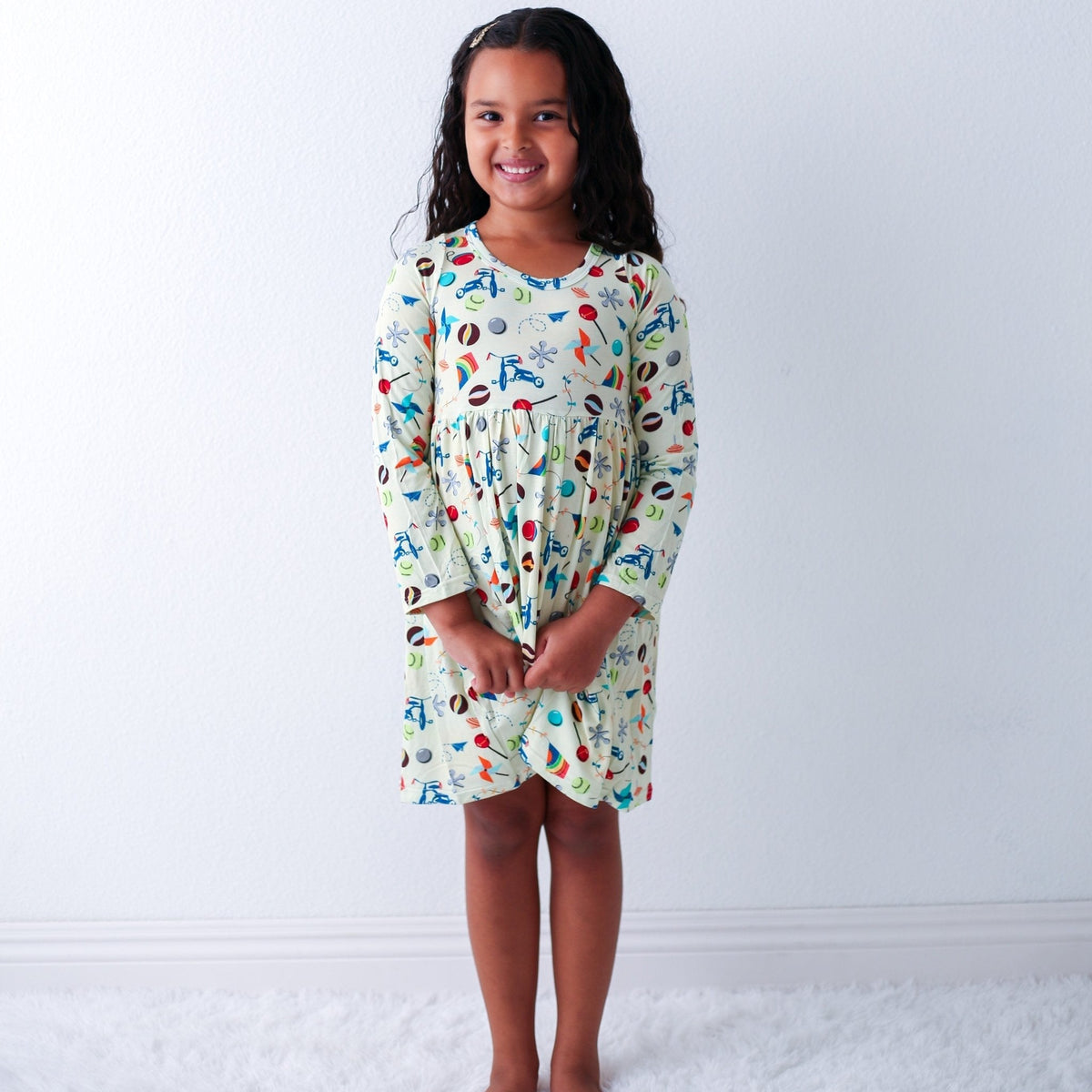 Long-sleeve toddler dress with a full twirl skirt, shown on a smiling child