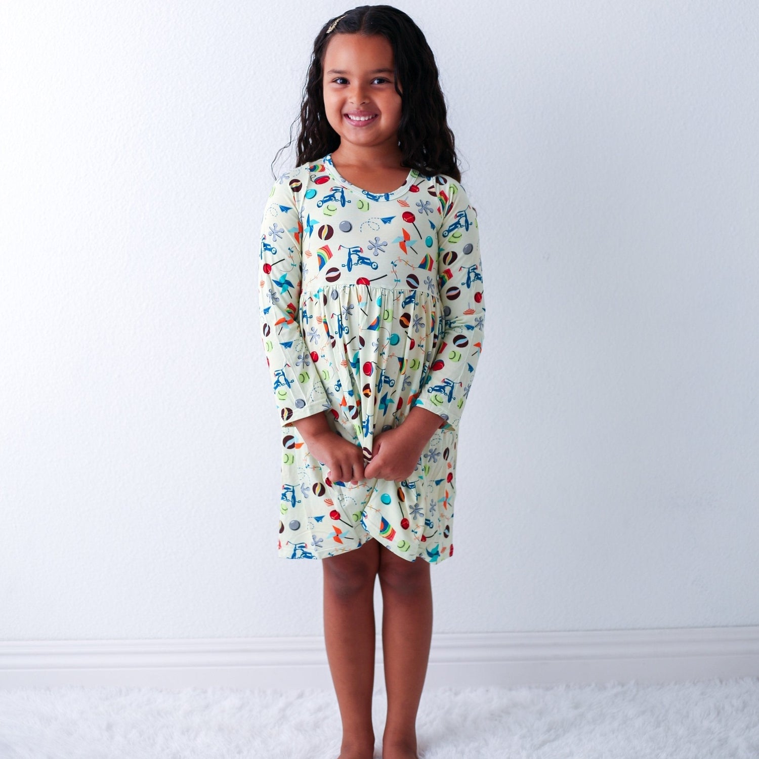 Long-sleeve toddler dress with a full twirl skirt, shown on a smiling child