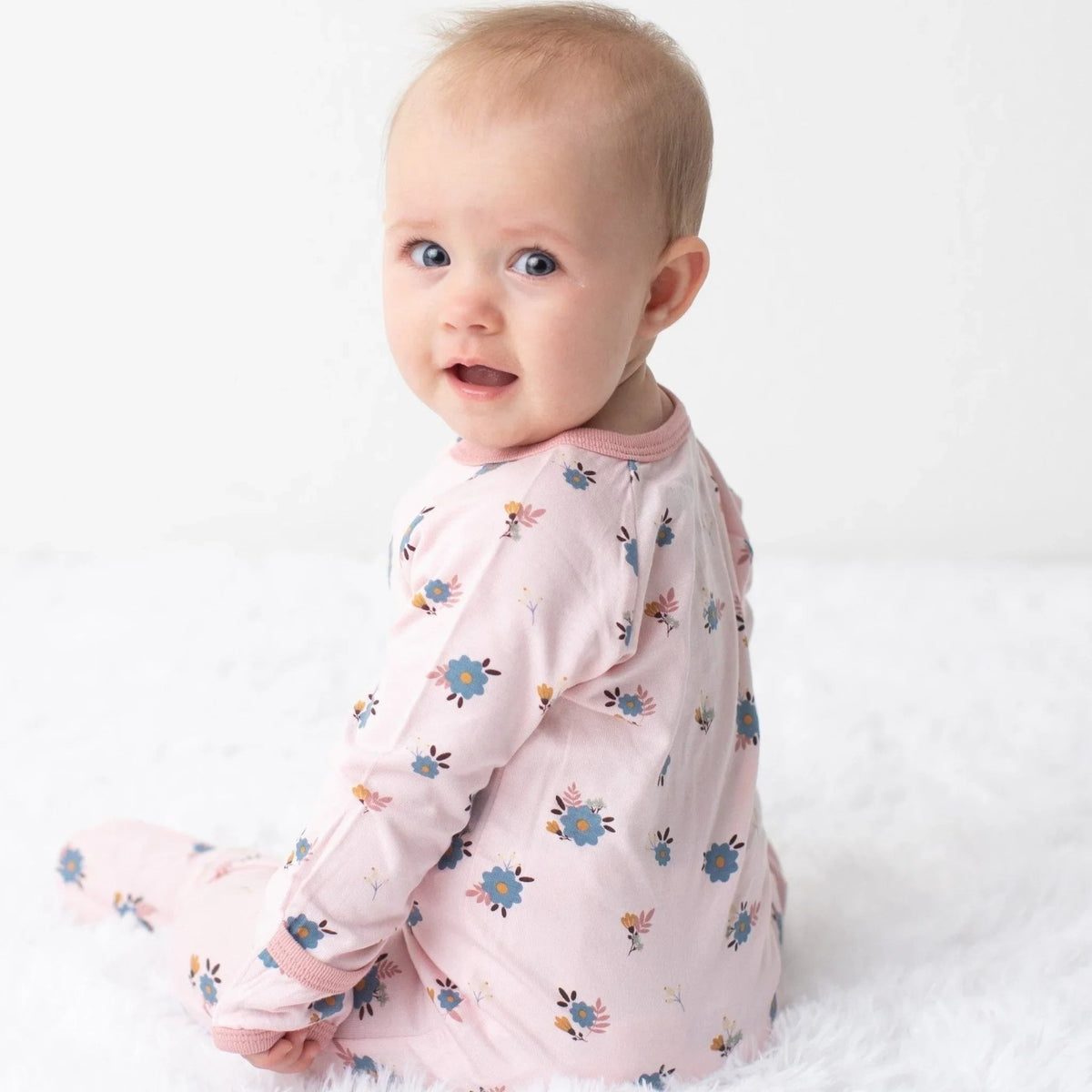 Footie pajamas with an all-over tiny floral print, footed legs, fold-over hand mittens, and a full-length front zipper
