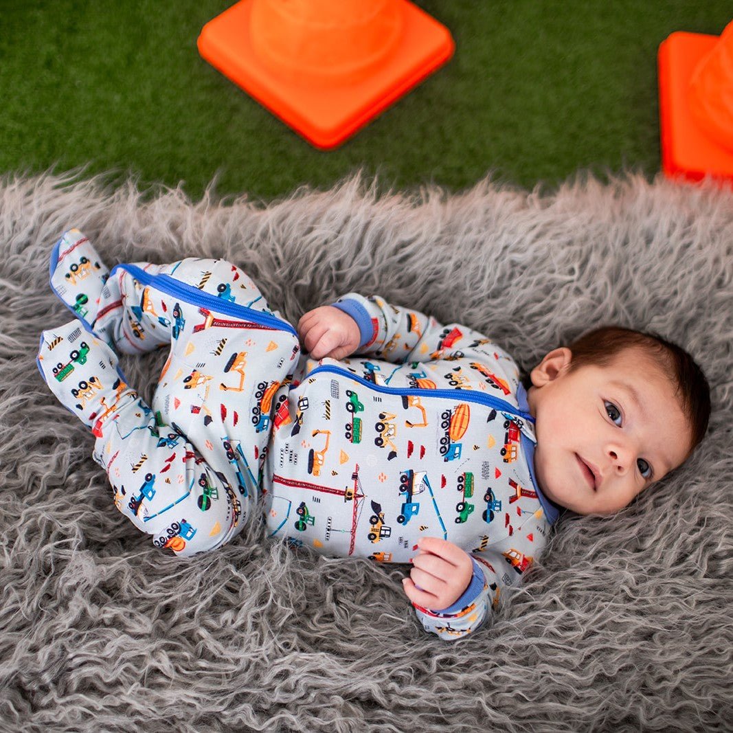 Baby footie pajamas with an all-over construction truck print and a two-way front zipper.