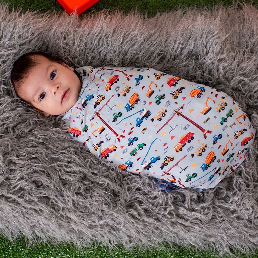 Baby swaddle blanket with a tiny trucker print, spread out square.