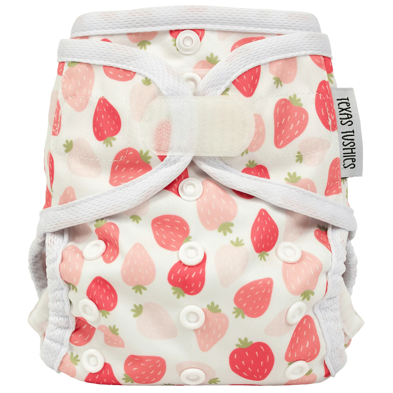 Tiny Tushies newborn cover with strawberry print and adjustable hook & loop closure.