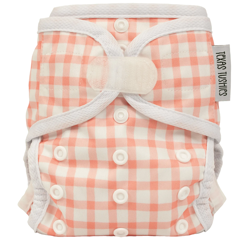 Tiny Tushies Newborn Cover with pink checkered pattern, adjustable hook & loop, for babies 5-20 lbs.