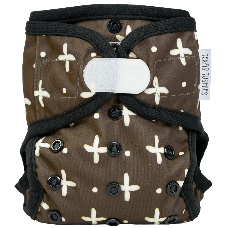 Tiny Tushies Newborn Cover with hook and loop fastener, featuring adjustable rise settings and wipeable PUL for newborns 5-20 lbs.