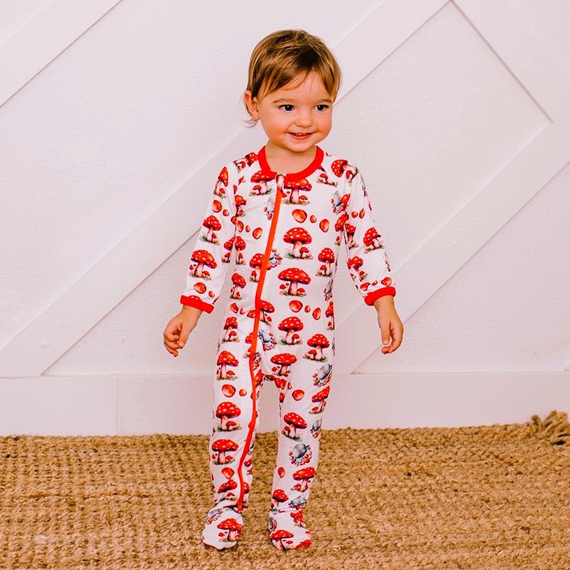 Baby footie pajamas with a toadstool and rocks print, full-length front zipper, and footed legs.