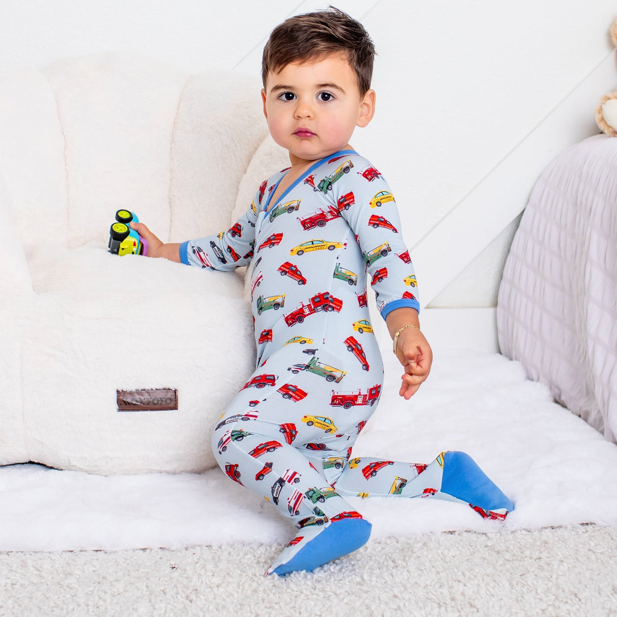 Baby footie pajamas in a transportation print with a two-way front zipper and covered feet