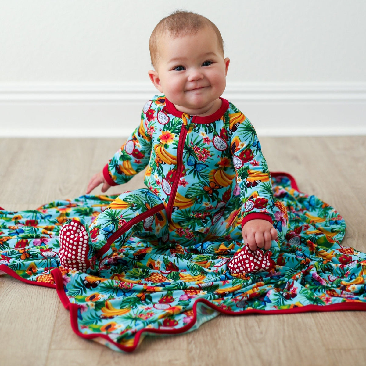 Baby footie pajamas with a colorful tropical fruit print, two-way zipper, and covered feet.