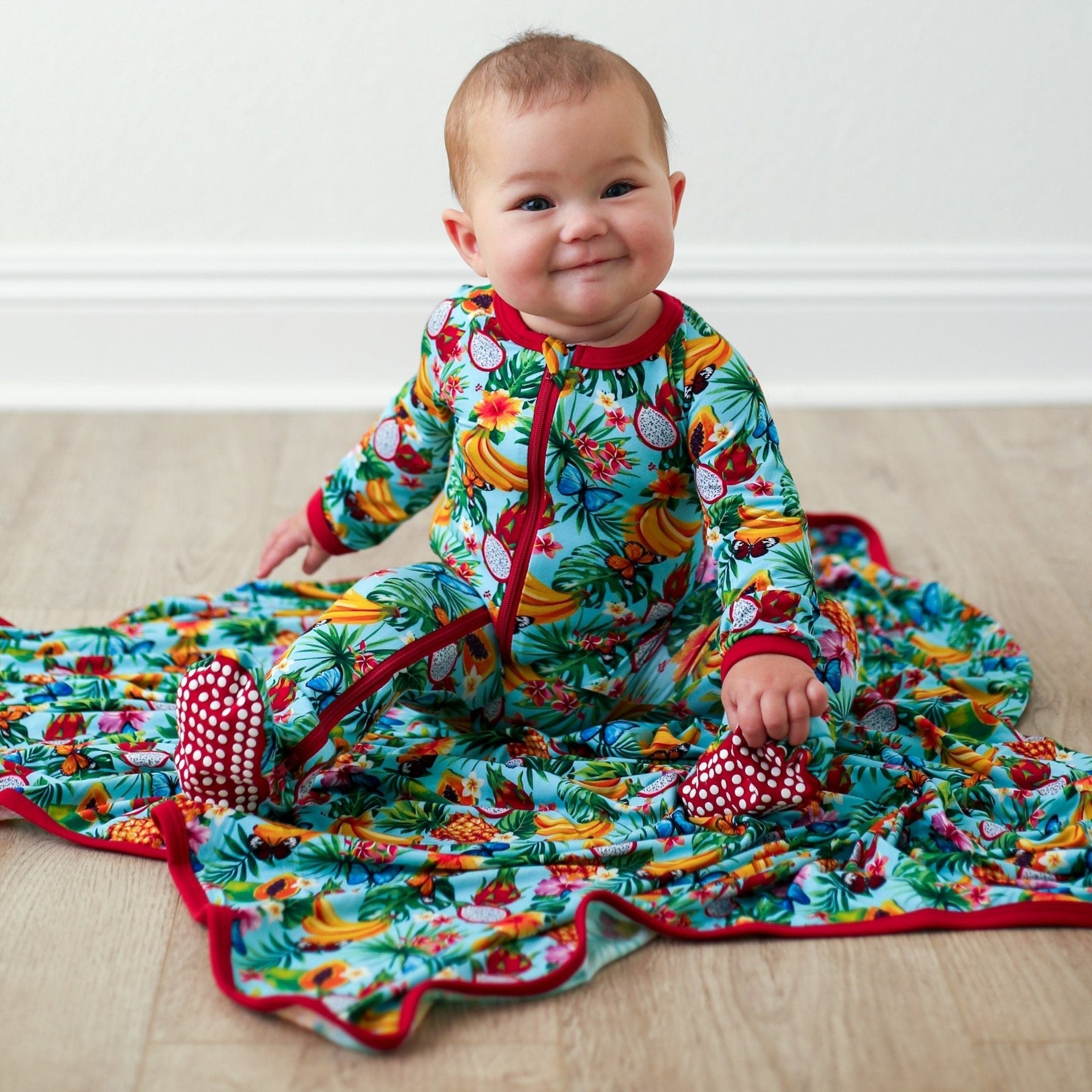 Baby footie pajamas with a colorful tropical fruit print, two-way zipper, and covered feet.