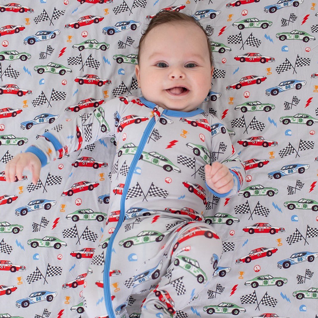 Turbo Tots footie pajamas in a car and vehicle print with a full-length front zipper and covered feet