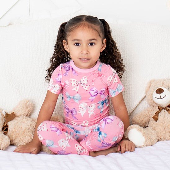 Short sleeve baby pajamas in a bow print, top and bottoms made from soft bamboo fabric
