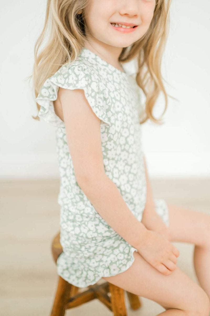 Two-piece short set in sage ditsy floral with ruffle details on a child.