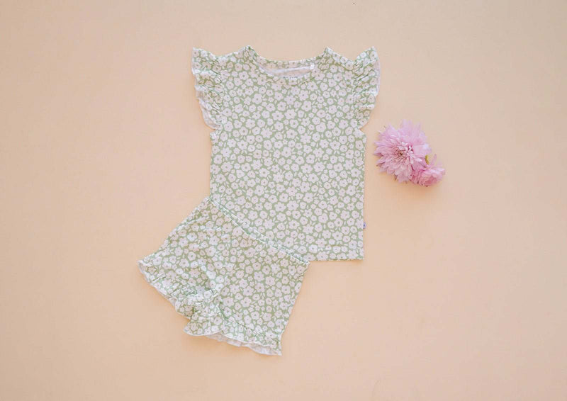 Sage ditsy floral two-piece short set with ruffle details on a beige background.