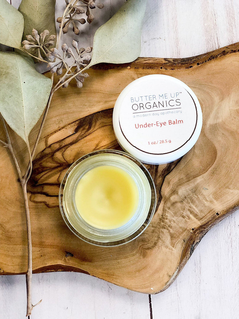 Caffeinated under eye balm for dark circles and puffy eyes on wooden surface.