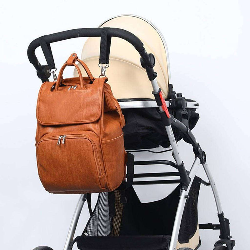 Water-resistant leather diaper backpack attached to stroller.