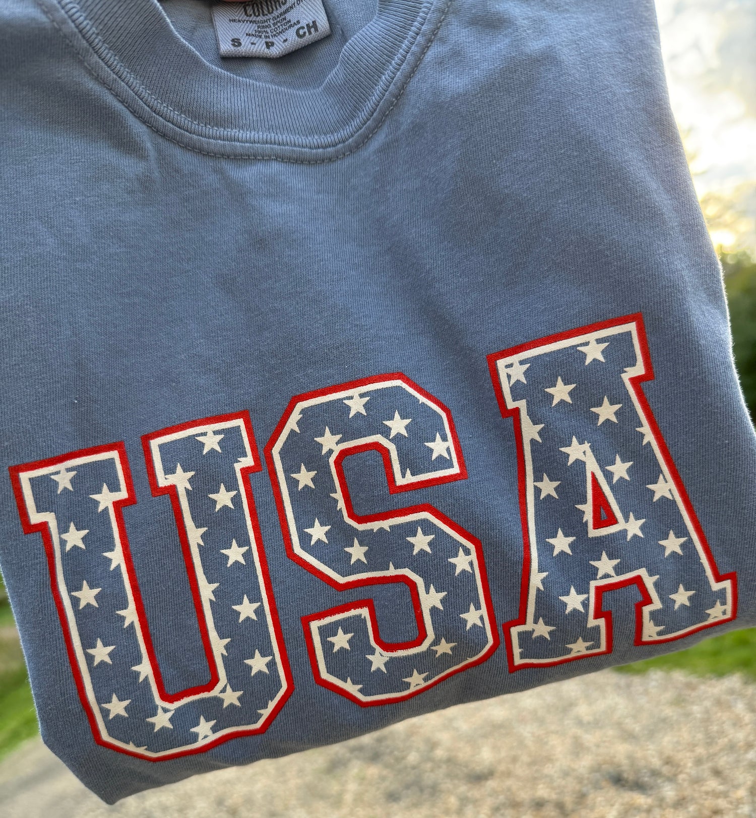 Little Joy Co. organic unisex baby t-shirt with a white background, featuring a blue USA stars design.
