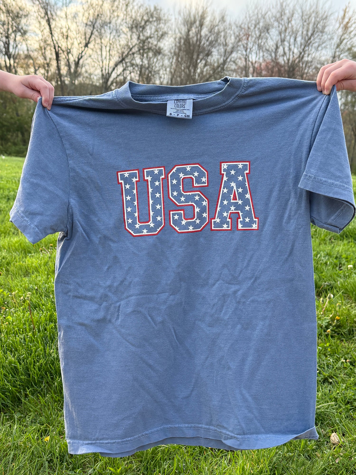 Little Joy Co. organic unisex baby t-shirt with a white background, featuring a blue USA stars design.