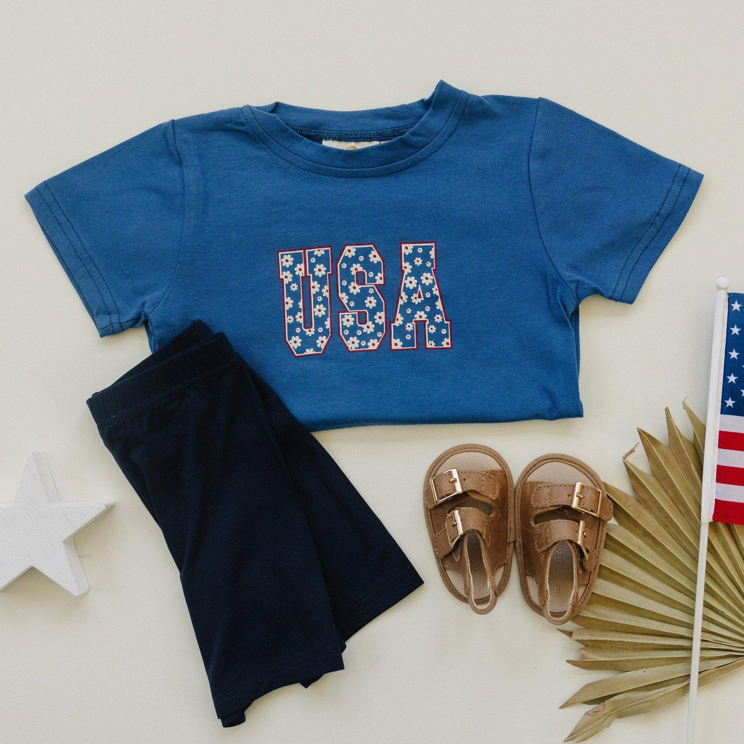 Little Joy Co. 100% cotton baby t-shirt in a soft, natural color, folded neatly.