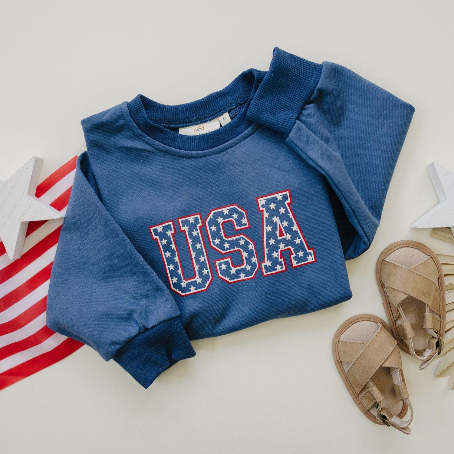 Little Joy Co. kids' crewneck sweatshirt with a red, white, and blue USA stars graphic.