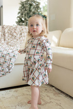 Bamboo twirl dress with a plaid pattern and teddy bears in green sweaters, flutter cap long sleeves, and a snap bodysuit.