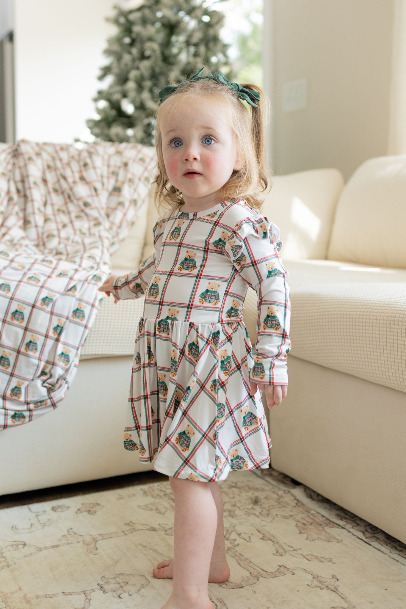 Bamboo twirl dress with a plaid pattern and teddy bears in green sweaters, flutter cap long sleeves, and a snap bodysuit.
