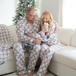 Unisex adult button-down pajama set with plaid pattern and teddy bears in green sweaters, paired with drawstring pants.
