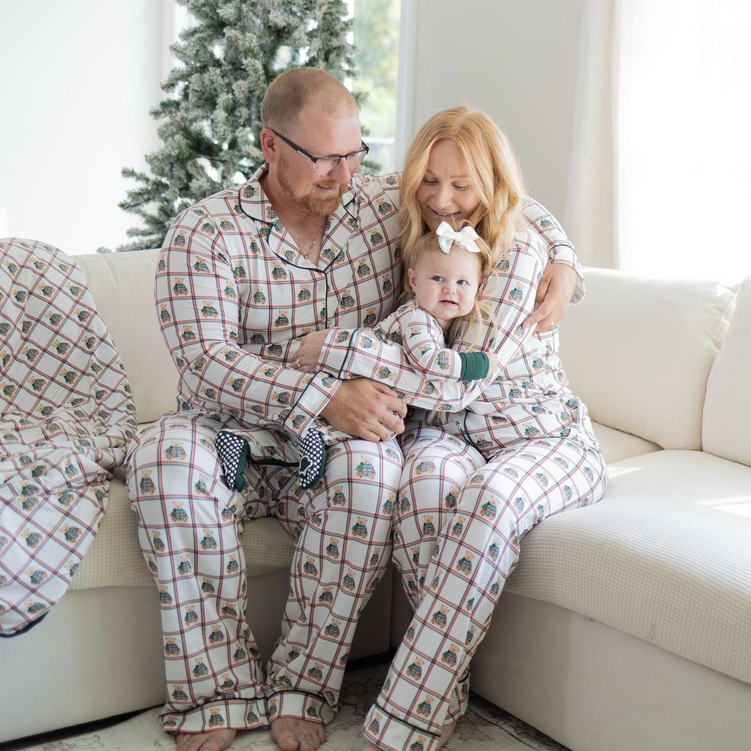 Unisex adult button-down pajama set with plaid pattern and teddy bears in green sweaters, paired with drawstring pants.