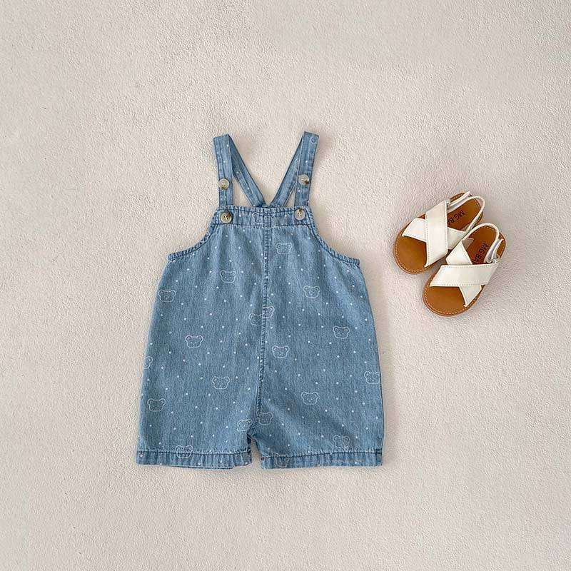 White Dots Denim Overalls with cross-back straps and white dot pattern, paired with white sandals.