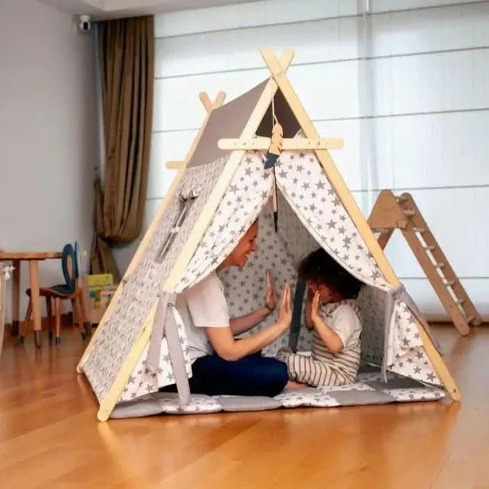 Extra large kids play tent with wooden poles, a play mat, and star lights set up as an indoor playhouse.