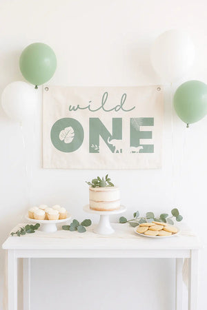 Canvas and wood banner with Wild One statement lettering in a jungle birthday theme