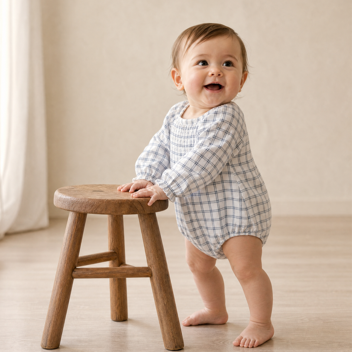 Long sleeve baby romper in window plaid print with a smocked neckline