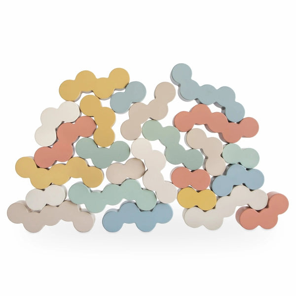 Wooden balance blocks with rounded bubble shapes in soft, calming painted colors, stacked and balanced