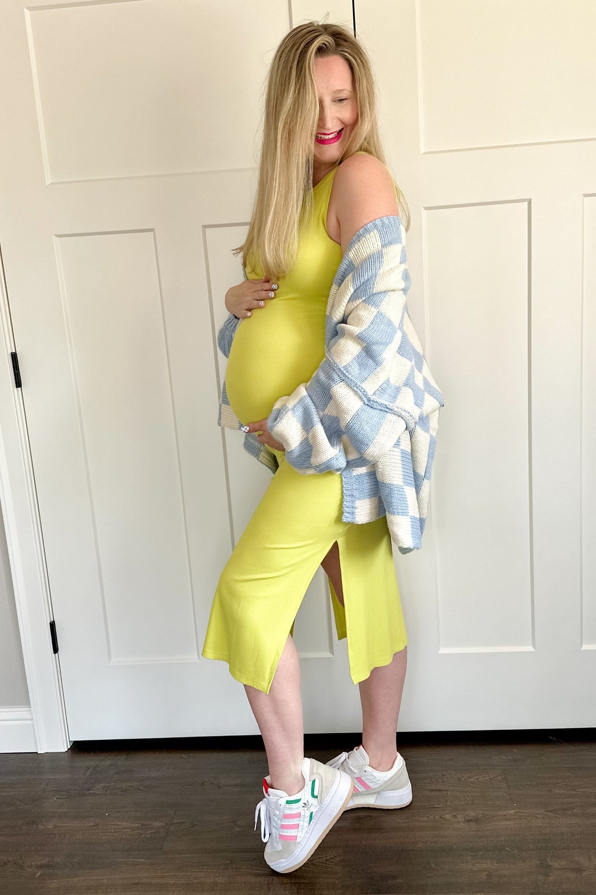 Model wearing a yellow ribbed maternity tank dress with a side slit, perfect for comfort and style.