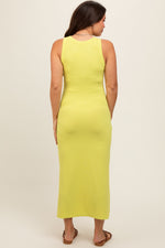 Model wearing a yellow ribbed maternity tank dress with a side slit, perfect for comfort and style.