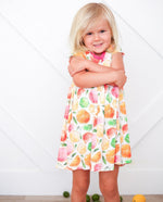 Short-sleeve baby dress with a colorful citrus fruit print in a twirl-ready skirt shape